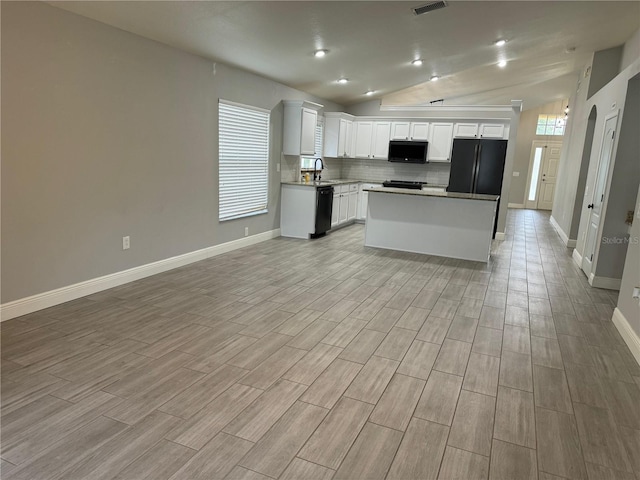 kitchen featuring light wood-type flooring, white cabinets, black appliances, vaulted ceiling, and a kitchen island