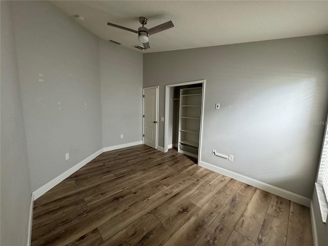 unfurnished bedroom with ceiling fan, lofted ceiling, and wood-type flooring