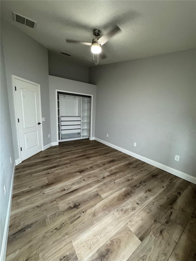 unfurnished bedroom with ceiling fan and wood-type flooring