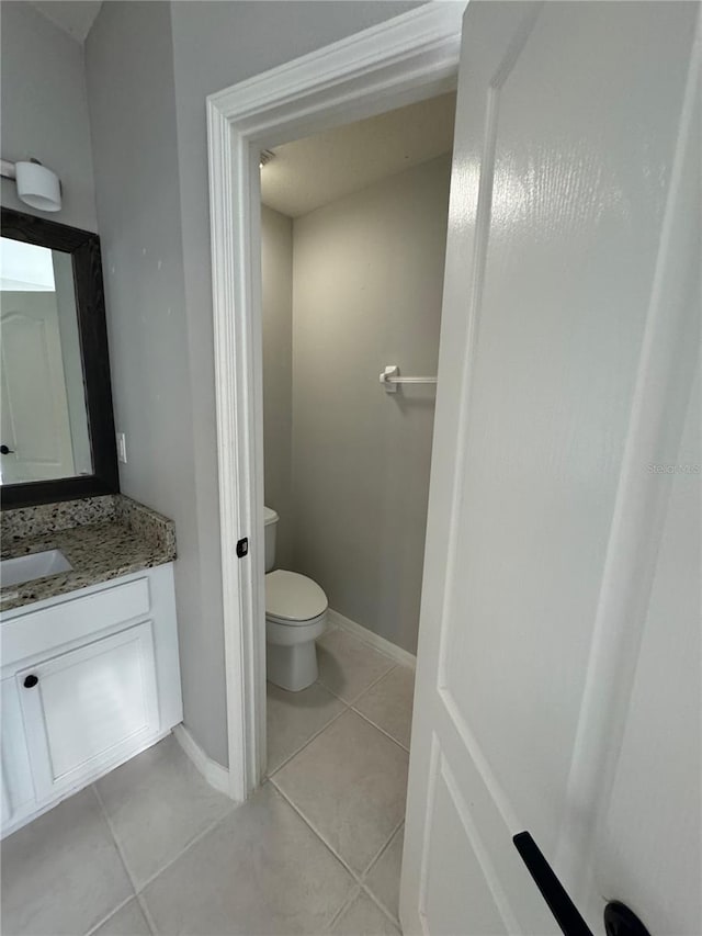 bathroom featuring tile patterned floors, vanity, and toilet