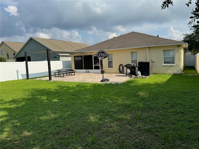 rear view of house with a lawn and a patio