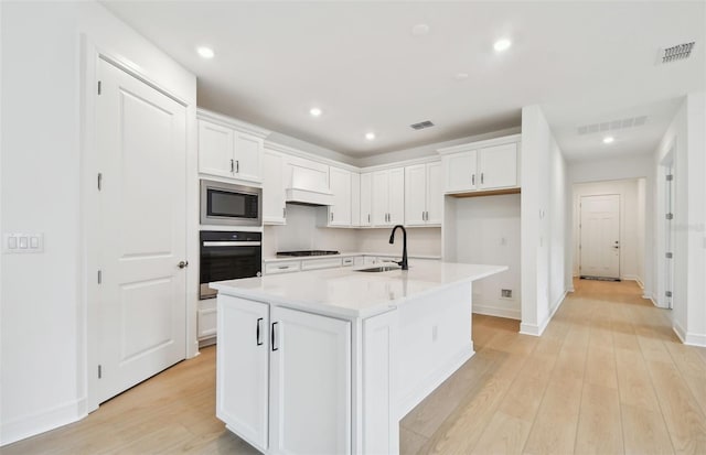 kitchen with white cabinetry, sink, an island with sink, and stainless steel appliances