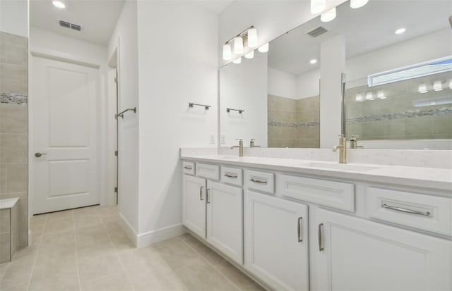 bathroom with a tile shower, tile patterned floors, and vanity