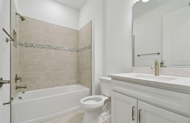 full bathroom featuring vanity, tiled shower / bath combo, and toilet