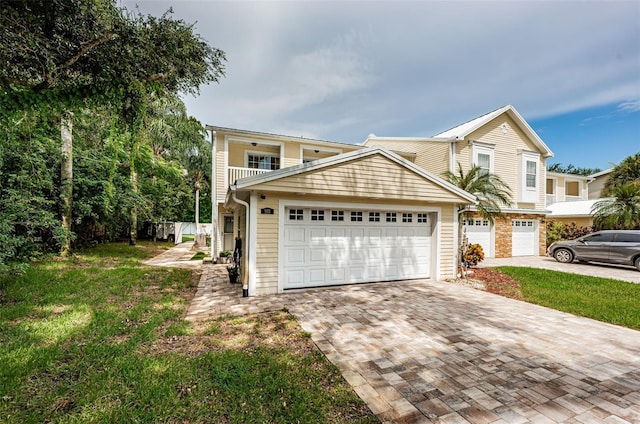 front facade with a balcony, a garage, and a front yard