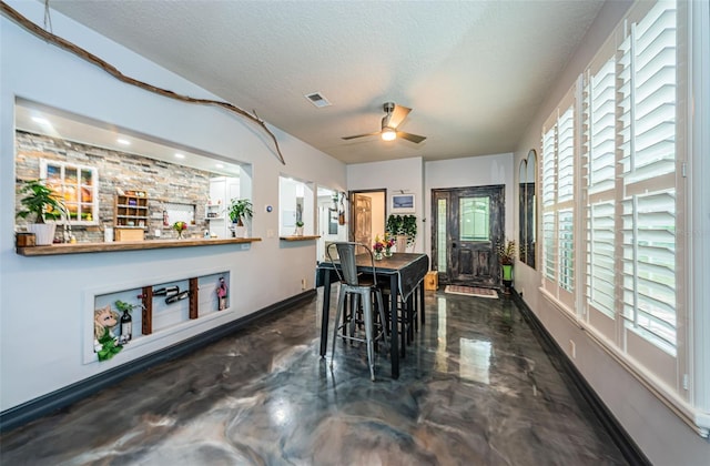 dining area featuring ceiling fan and a textured ceiling