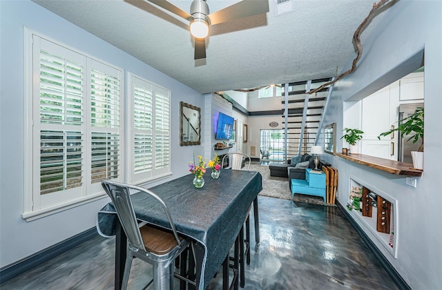 dining room featuring ceiling fan and a textured ceiling