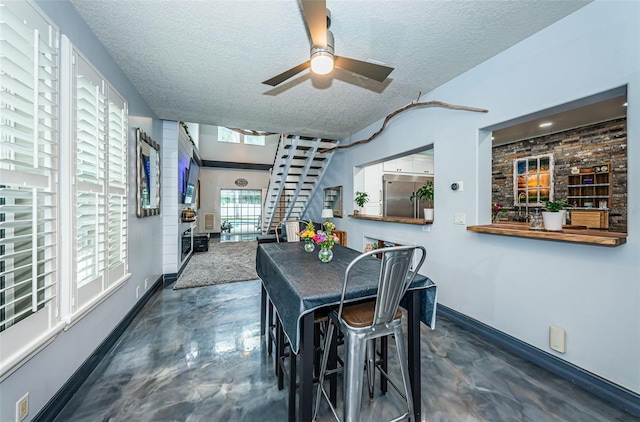 dining area featuring ceiling fan and a textured ceiling