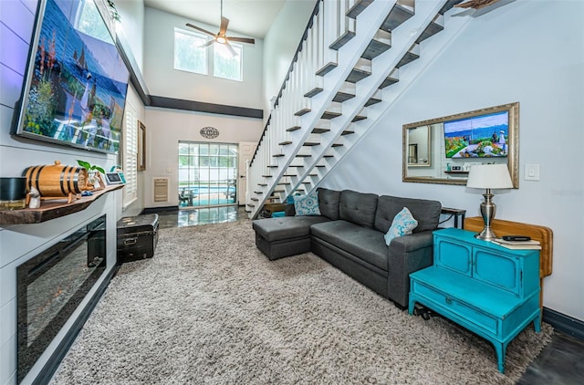 living room featuring ceiling fan, a high ceiling, and a wealth of natural light