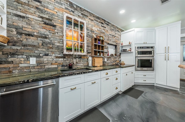 kitchen featuring dark stone countertops, sink, white cabinets, and appliances with stainless steel finishes