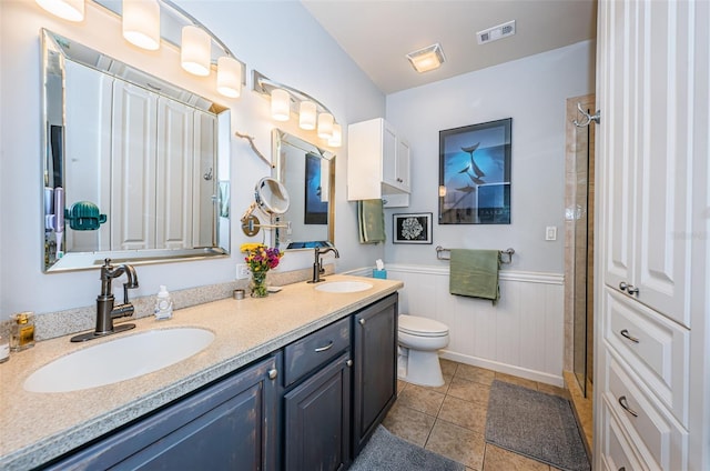 bathroom featuring vanity, a shower with shower door, tile patterned floors, and toilet