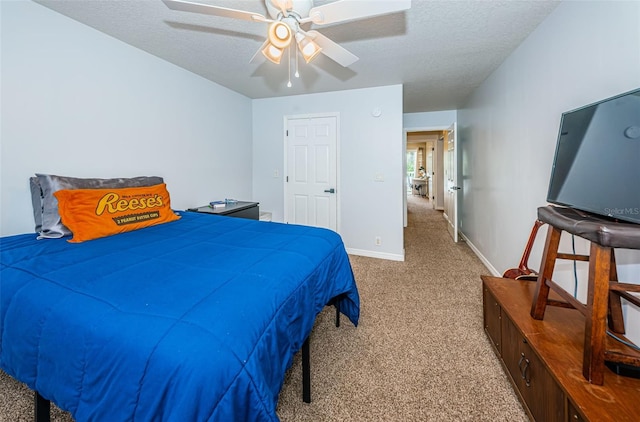 bedroom with ceiling fan, carpet, and a textured ceiling