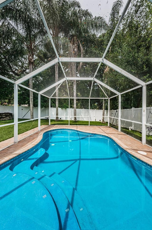 view of pool with glass enclosure