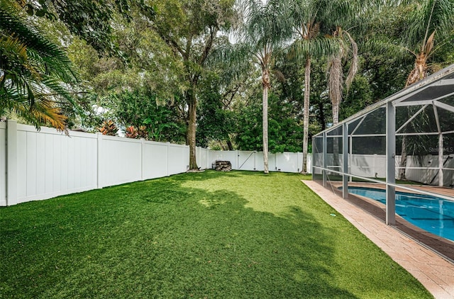 view of yard with a lanai and a fenced in pool