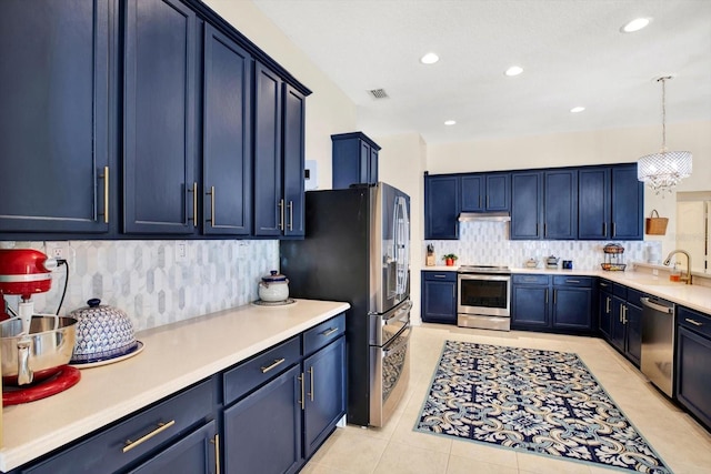 kitchen featuring backsplash, blue cabinetry, appliances with stainless steel finishes, light tile patterned flooring, and pendant lighting