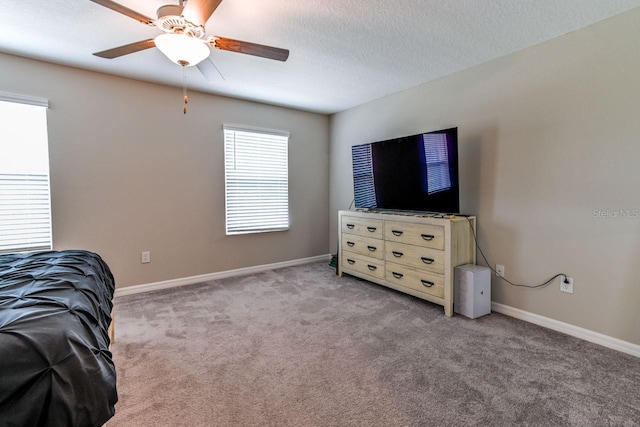 carpeted bedroom with ceiling fan and a textured ceiling