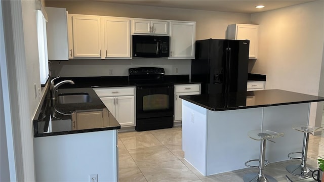 kitchen with a kitchen island, a breakfast bar, white cabinetry, sink, and black appliances