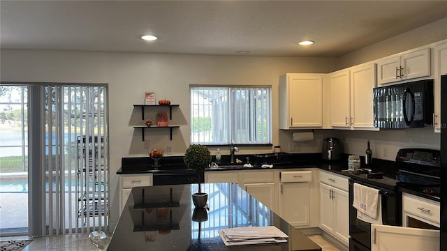 kitchen with white cabinetry, sink, and black appliances