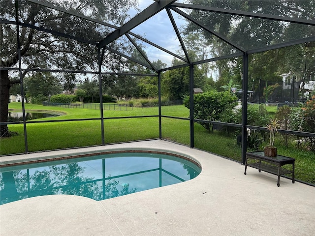 view of swimming pool featuring a water view, a lanai, a yard, and a patio area