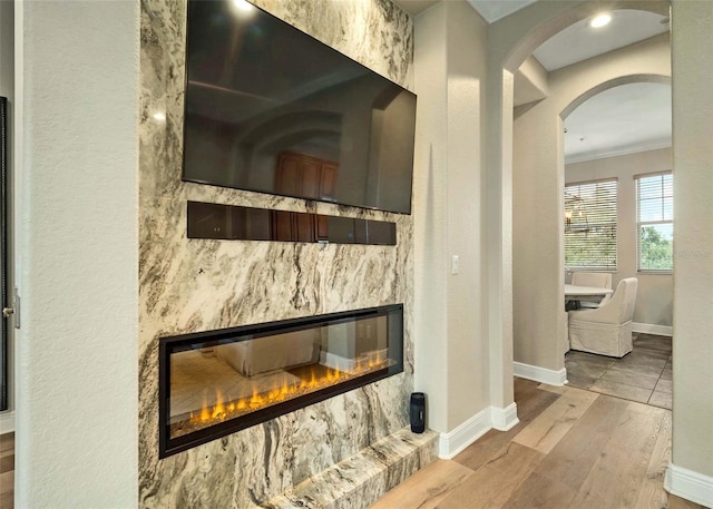 details featuring a high end fireplace, hardwood / wood-style flooring, and crown molding