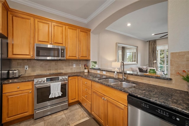 kitchen with decorative backsplash, dark stone counters, appliances with stainless steel finishes, ornamental molding, and sink