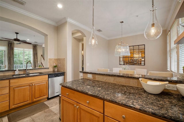 kitchen featuring dishwasher, ceiling fan, dark stone counters, sink, and decorative light fixtures