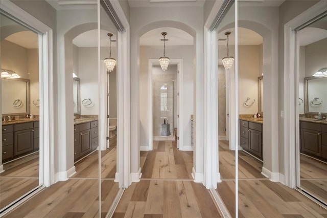 bathroom featuring toilet, wood-type flooring, vanity, and a chandelier