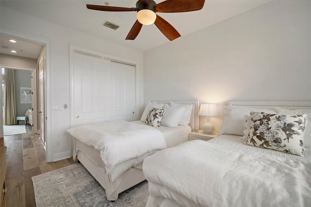 bedroom featuring ceiling fan, hardwood / wood-style floors, and a closet