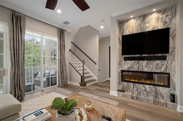 living room with a large fireplace, ceiling fan, and hardwood / wood-style floors