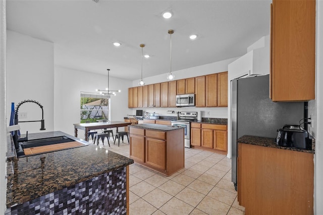 kitchen featuring stainless steel appliances, sink, pendant lighting, light tile patterned floors, and a center island