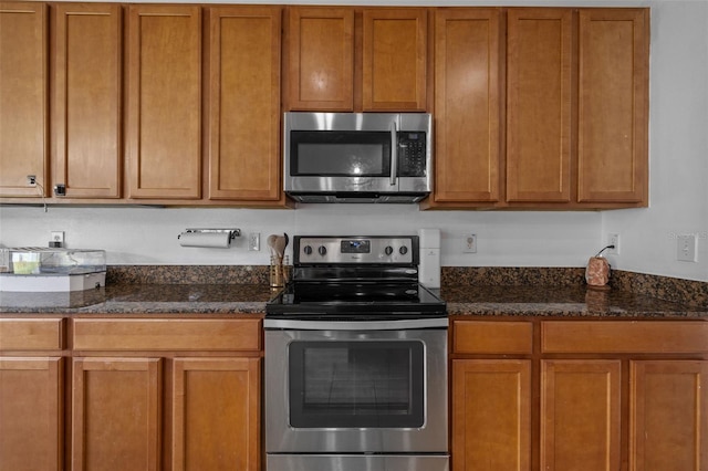 kitchen featuring appliances with stainless steel finishes and dark stone countertops