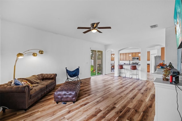 living room with light hardwood / wood-style floors and ceiling fan