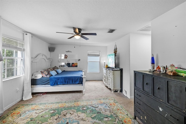 carpeted bedroom with a textured ceiling and ceiling fan