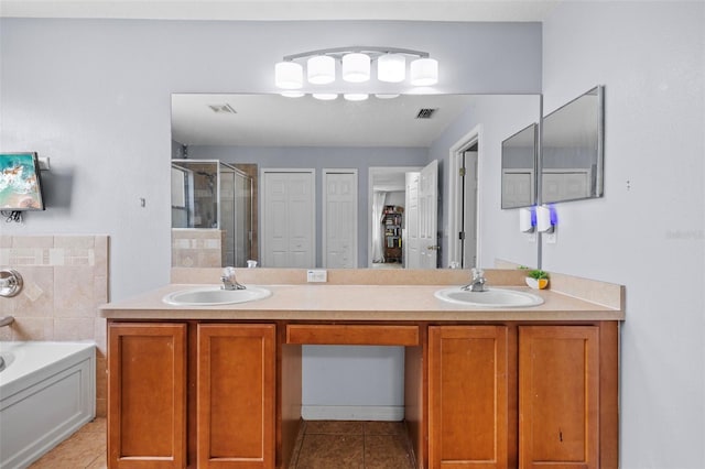 bathroom featuring tile patterned floors, dual bowl vanity, and separate shower and tub