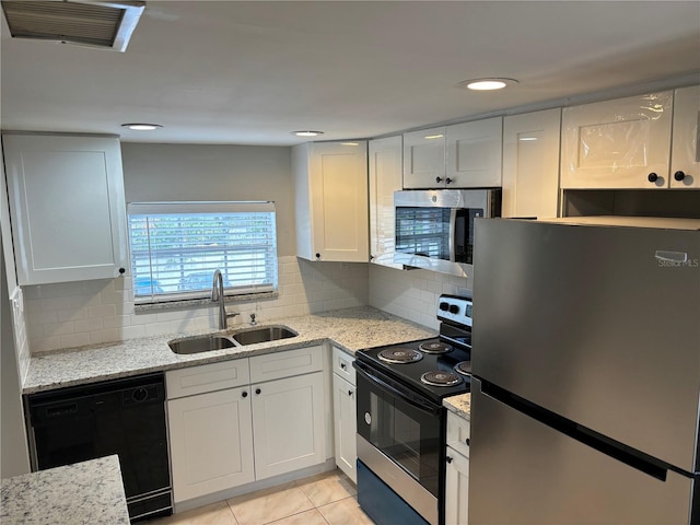 kitchen with decorative backsplash, white cabinetry, sink, and stainless steel appliances