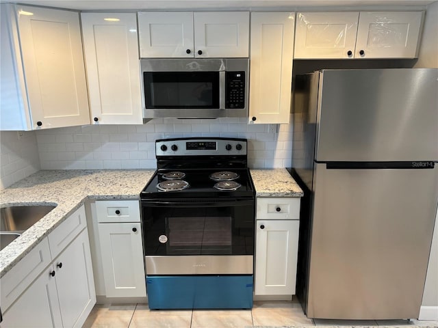 kitchen featuring light stone counters, white cabinetry, and appliances with stainless steel finishes