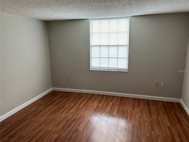 spare room with dark wood-type flooring and a textured ceiling