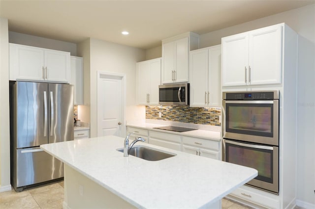 kitchen featuring white cabinetry, a kitchen island with sink, sink, and appliances with stainless steel finishes