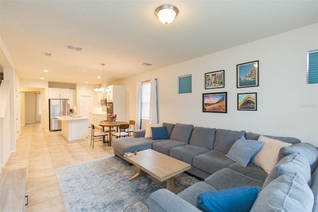 living room featuring light tile patterned floors and an inviting chandelier