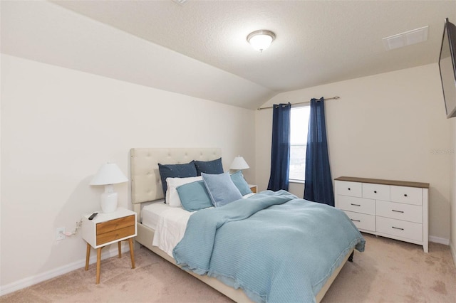 carpeted bedroom with a textured ceiling and lofted ceiling