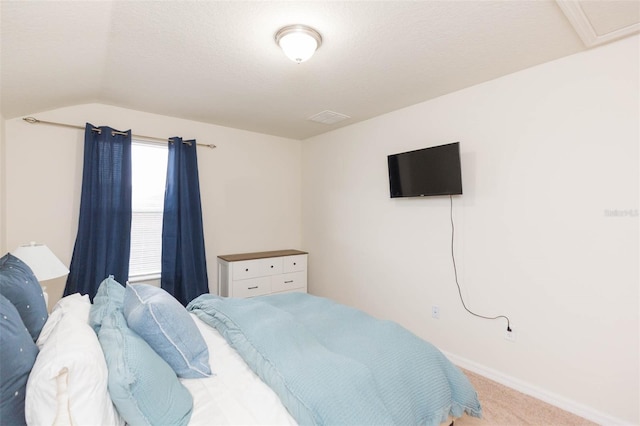 carpeted bedroom with lofted ceiling and a textured ceiling