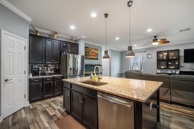 kitchen featuring crown molding, stainless steel appliances, sink, an island with sink, and ceiling fan