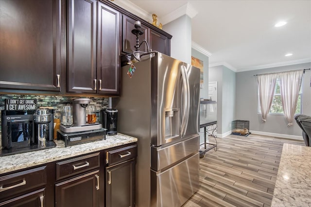 kitchen with ornamental molding, light hardwood / wood-style flooring, light stone counters, decorative backsplash, and stainless steel refrigerator with ice dispenser