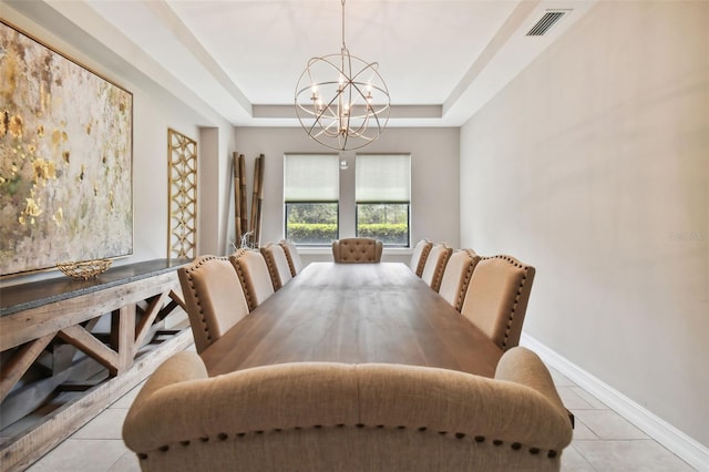 tiled dining room with a raised ceiling and an inviting chandelier