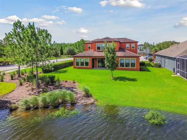 back of property featuring a water view and a yard