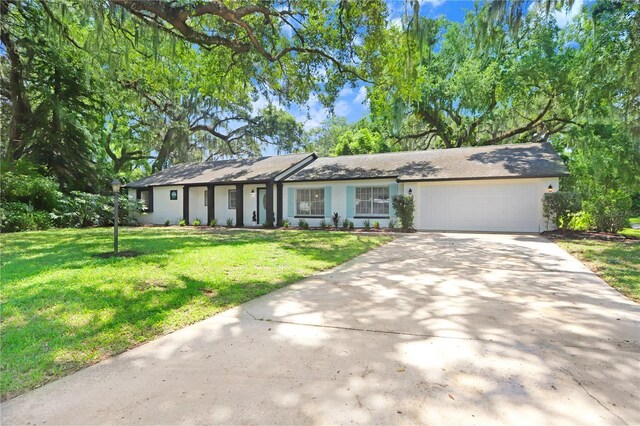 ranch-style house featuring a front lawn and a garage