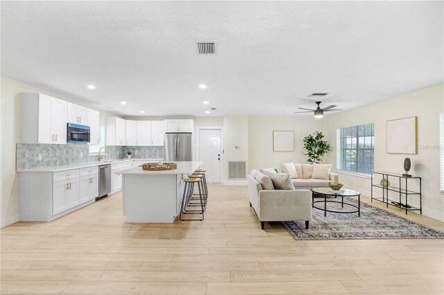 living room featuring light wood-type flooring and ceiling fan