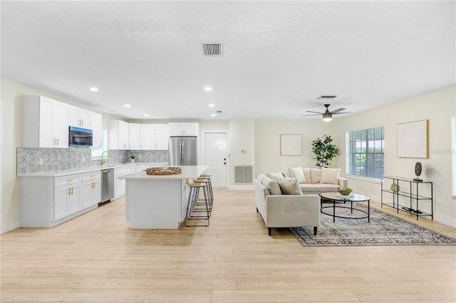 living room with visible vents and light wood-style flooring