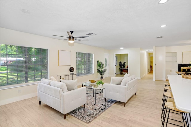 living room featuring light hardwood / wood-style flooring and ceiling fan