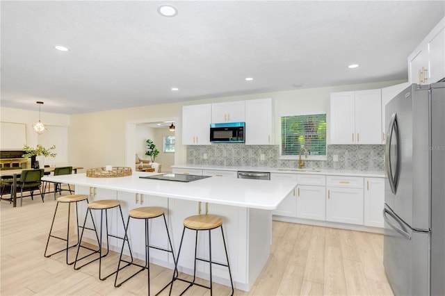 kitchen featuring sink, light hardwood / wood-style flooring, a kitchen island, and black appliances